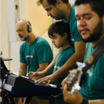 Integrantes do ministério de música tocando instrumentos e cantando durante a missa no Santuário do Rocio.