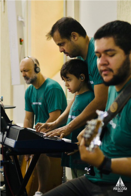 Integrantes do ministério de música tocando instrumentos e cantando durante a missa no Santuário do Rocio.