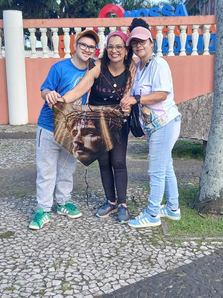 Pipa artesanal com imagem de Cristo estampada na rabiola voando no céu do Santuário.
