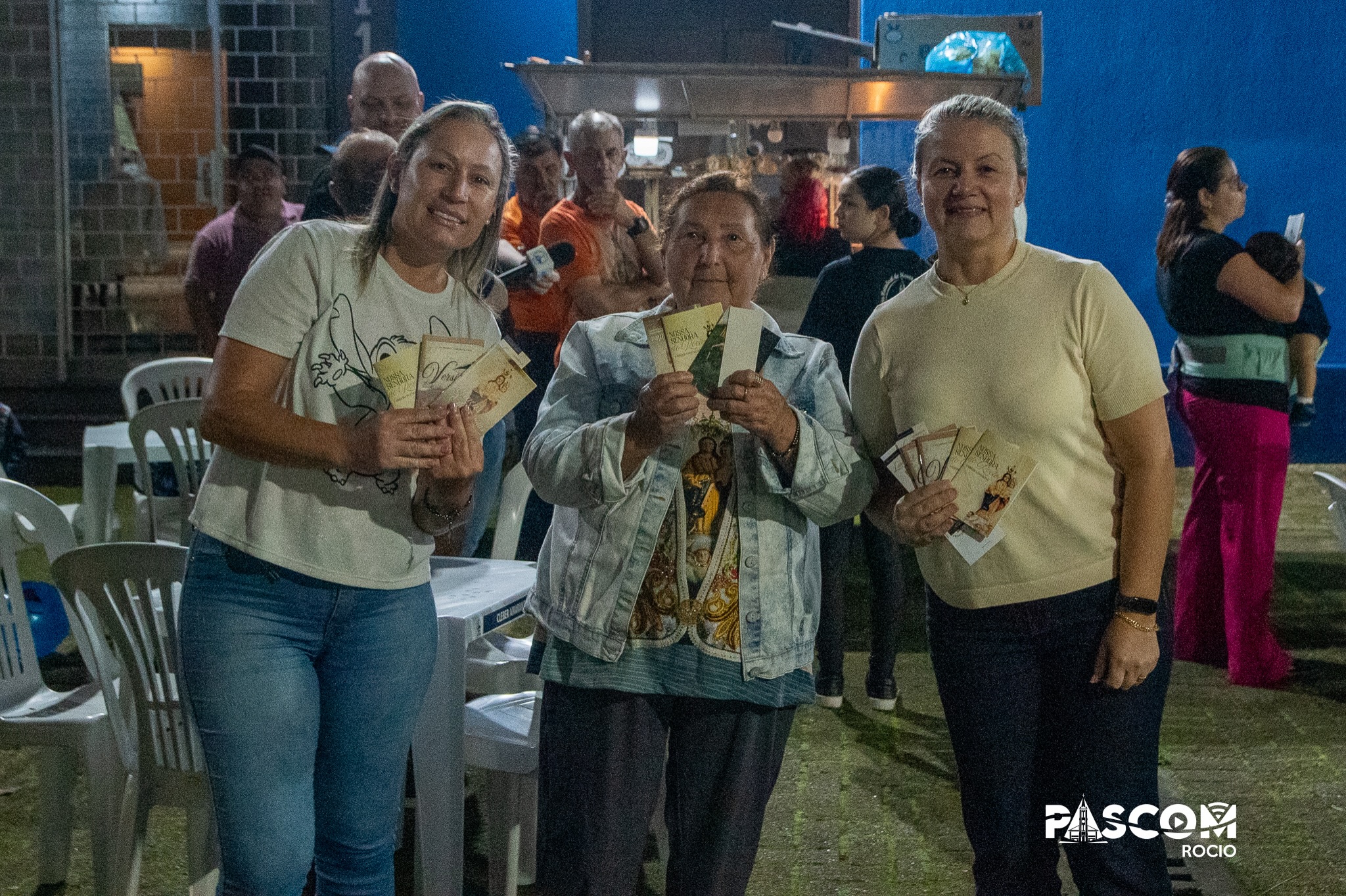 Devotas mostra o livreto Versículos, do Padre Dirson, no lançamento no Santuário do Rocio